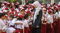Guru mengatur para murid sebelum upacara di SD Pasar Baru 05, Jakarta, Senin (27/7/2015). Usai libur panjang Idul Fitri para siswa kembali beraktivitas mengikuti pelajaran di sekolah untuk tahun ajaran 2015-2016. (Liputan6.com/Faizal Fanani)