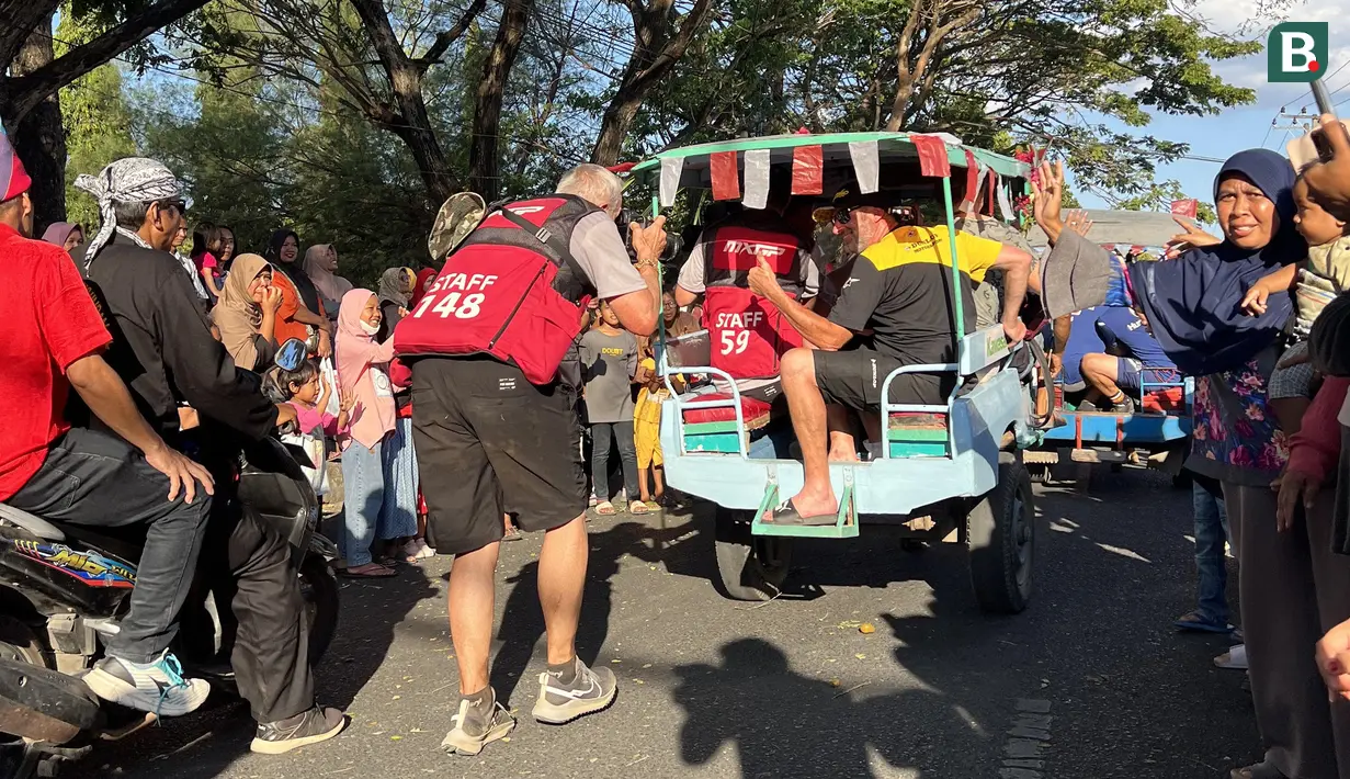 Suasana seru parade pembalap MXGP Sumbawa 2023 di Jalan Yos Sudarso, Sumbawa, NTB, Jumat (23/6/2023) menjelang balapan MXGP Sumbawa 2023 di Sirkuit Samota pada 24-25 Juni 2023. (Bola.com/Wiwig Prayugi)