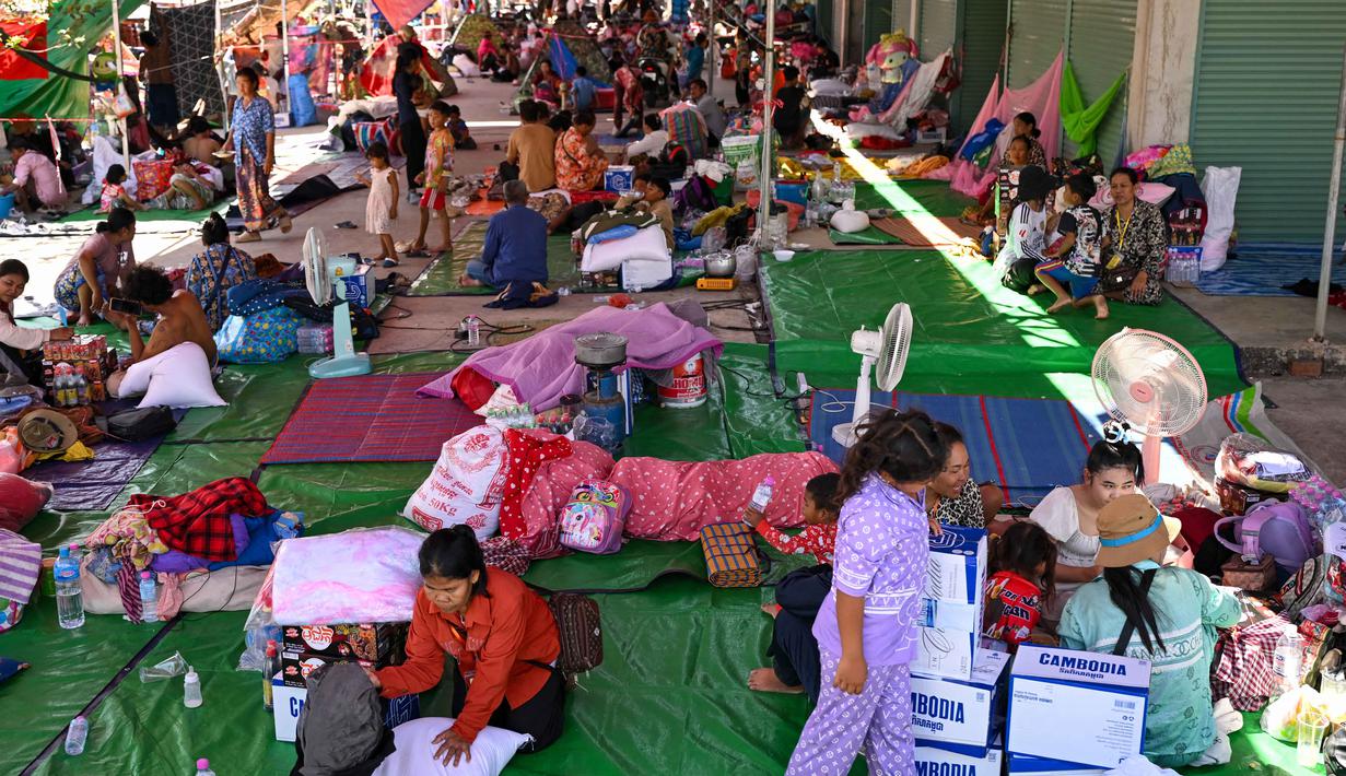 Gelombang pengungsian menjadi konsekuensi paling mengerikan dari eskalasi konflik Kamboja dan Thailand. Tampak dalam foto, para pengungsi berkumpul di kamp sementara di provinsi Banteay Meanchey, Kamboja, pada Sabtu 13 Desember 2025, di tengah bentrokan di sepanjang perbatasan Kamboja-Thailand. (TANG CHHIN SOTHY/AFP)