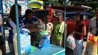 Petugas desa menimbang botol plastik dan sampah plastik lainnya yang akan ditukar dengan beras. Program tersebut bertujuan untuk mengedukasi masyarakat tentang pemilahan sampah yang benar. (PNA/ Villamor Visaya Jr.)