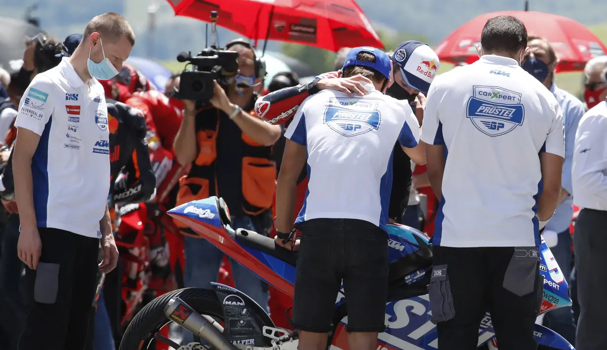 Rekan satu tim dari pebalap Moto3 yang berusia 19 tahun, Jason Dupasquier, berdiri di dekat sepeda motornya usai mengheningkan cipta selama satu menit untuk mengenangnya sebelum dimulainya MotoGP Italia di sirkuit Mugello. (Foto: AP Photo/Antonio Calanni)