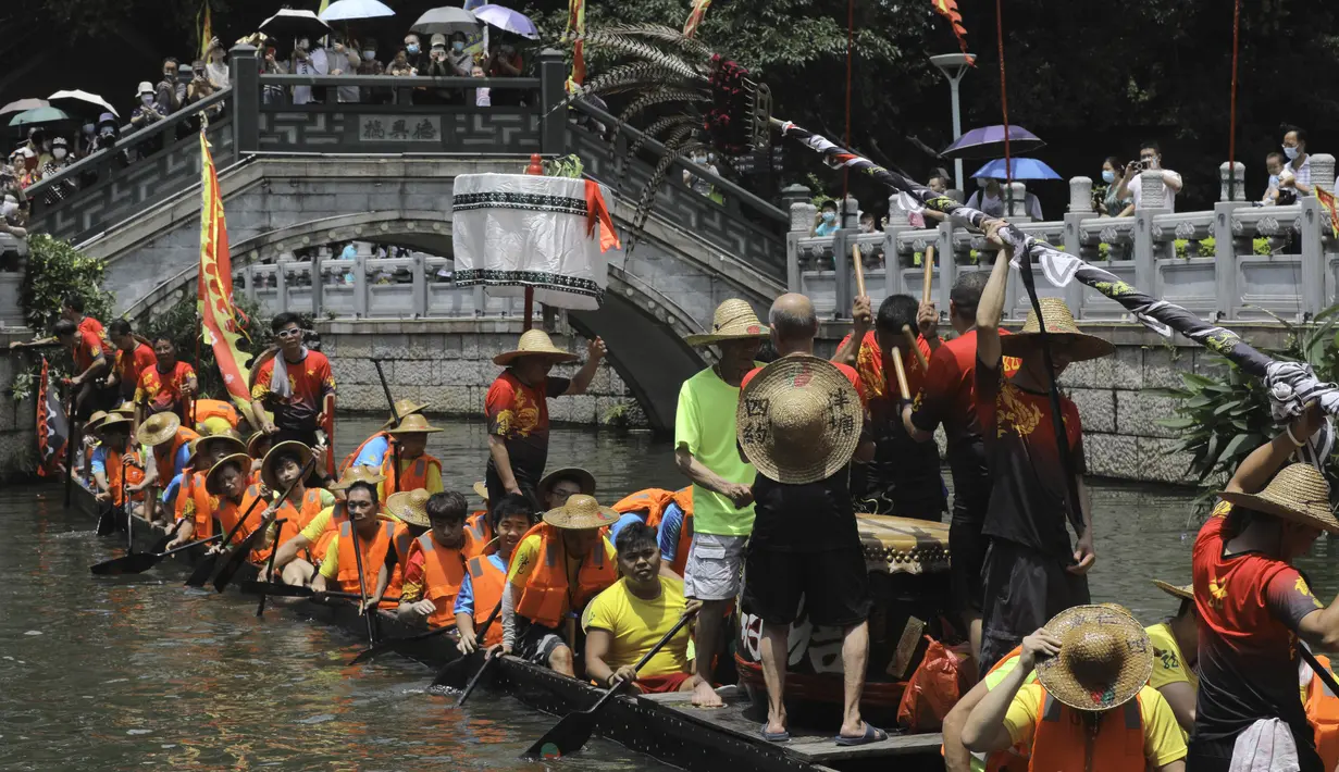 Peserta perahu naga dari desa Panting mendayung di sepanjang kanal di kawasan bersejarah Teluk Lychee di Guangzhou di Provinsi Guangdong, China selatan, Jumat, 3 Juni 2022. Perlombaan perahu naga kembali digelar di beberapa bagian China untuk pertama kalinya sejak merebaknya pandemi pada akhir 2019, saat pembatasan dicabut bersama dengan penurunan besar  kasus COVID-19. (AP Photo/Caroline Chen)