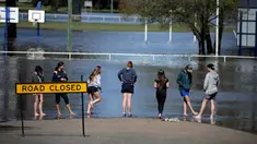 Warga melihat banjir yang melanda Kota Forbes, kawasan pedalaman di New South Wales, Australia, Selasa (27/9). Banjir ini merupakan banjir terparah sejak 26 tahun terakhir. (REUTERS / Jason Reed)