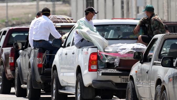 Petugas membawa peti mati menuju sebuah pemakaman di Guayaquil, Ekuador, Kamis (2/4/2020). Sejumlah video yang menyebar di media sosial memperlihatkan bagaimana jenazah korban vurus corona COVID-19 dibiarkan telantar di jalanan Guayaquil. (Enrique Ortiz/AFP)