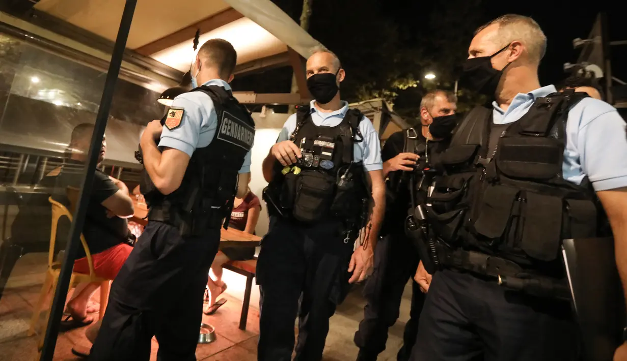 Polisi Prancis berpatroli untuk mengontrol kewajiban penggunaan masker di jalan-jalan Argeles-sur-Mer, Prancis selatan, Rabu (13/8/2020). Pemakaian masker di beberapa area ramai di sekitar Paris merupakan kewajiban sebagai upaya untuk membendung peningkatan tajam infeksi covid-19. (RAYMOND ROIG/AFP)