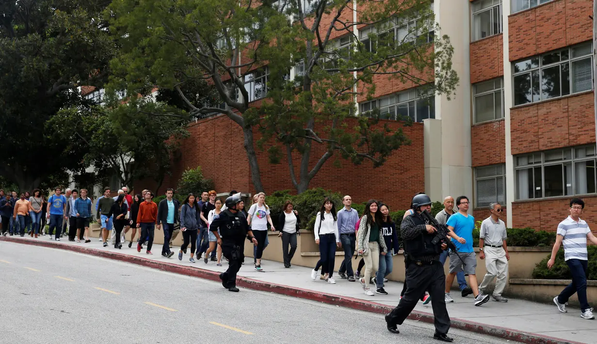 Petugas mengevakuasi sejumlah orang dari lokasi penembakan di Universitas California Los Angeles (UCLA), Rabu (1/6). Polisi mencurigai penembakan yang menewaskan dua orang itu merupakan aksi bunuh diri. (REUTERS/Patrick T. Fallon)