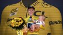 Pebalap Tim DSM, Lorena Wiebes menggendong anaknya saat merayakan kemenagannya di etape pertama Tour de France Wanita 2022 yang menempuh jarak sepanjang 81,6 km dari Tour Eiffel hingga Champs-Elysees, Paris pada 24 Juli 2022. (AFP/Jeff Pachoud)