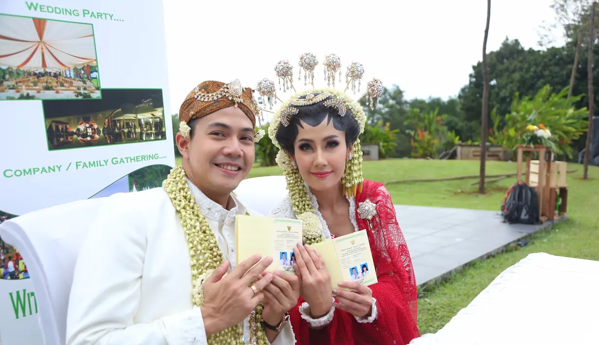 Arie dan Rasti memamerkan buku nikahnya. Keduanya melakukan akad nikah di teras hotel. Jelang acara, hujan mulai menguyur lokasi tempat terbuka yang sebelumnya telah direncanakan sebagai tempat akad nikah. (Daniel Kampua/Bintang.com)