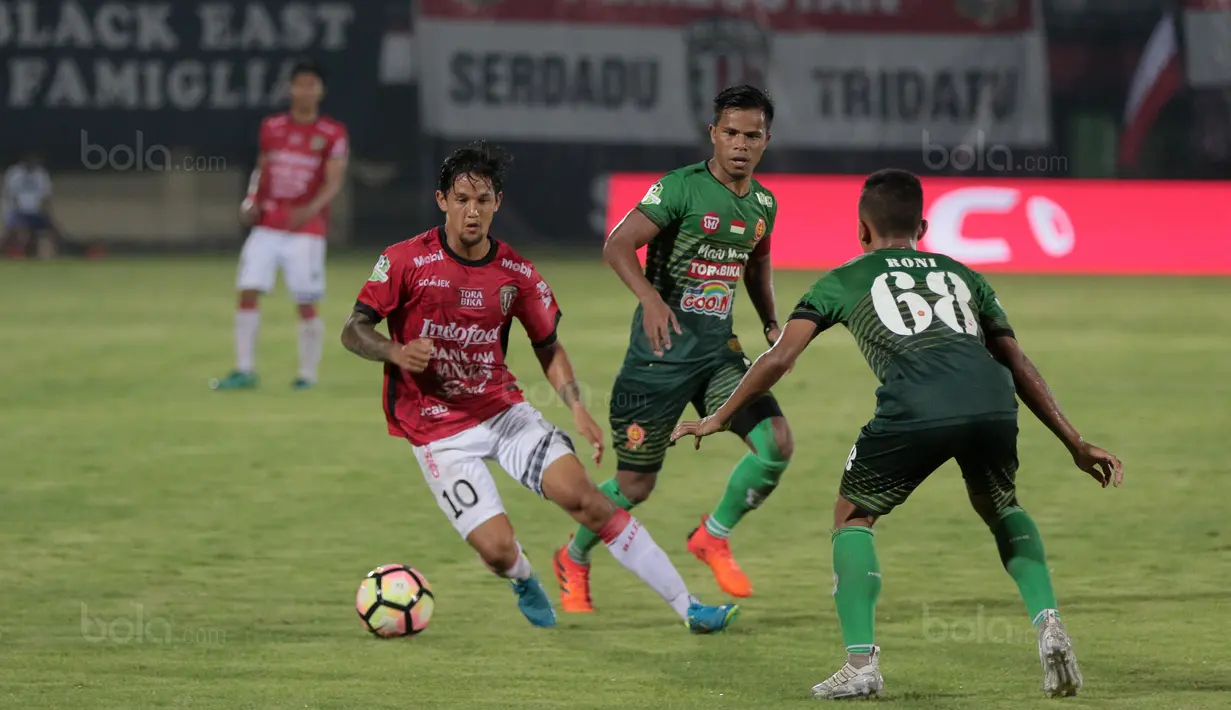 Pemain Bali United, Irfan Bachdim (kiri) melwati adangan para pemain PS TNI pada lanjutan Liga 1 2017 di Stadion Kapten I Wayan Dipta, Gianyar, Bali (20/102017). Bali United menang 2-1. (Bola.com/NIcklas Hanoatubun)