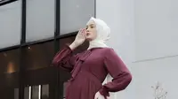 Gamis ruffle maroon dengan aksen pita di bagian leher dikenakan Sabrina Salsabila, dipadukan kerudung putihnya. @sabrinasosiawan