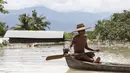 Seorang warga menggunakan perahu untuk melintasi jalanan yang terendam banjir di kawasan Kalay, Sagaing, Myanmar, Minggu (2/8/2015). Setidaknya 21 orang tewas akibat banjir yang melanda empat wilayah di Myanmar. (REUTERS/Soe Zeya Tun)