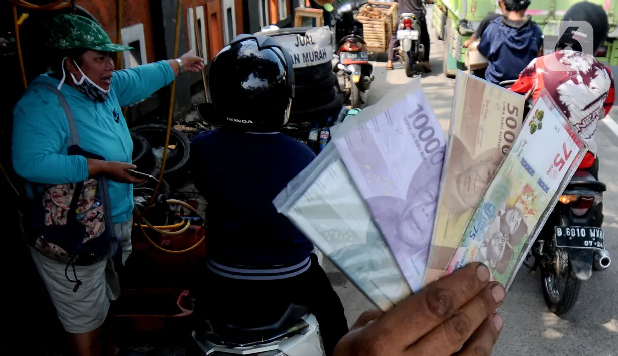 Penjual jasa penukaran uang menawarkan uang baru di kawasan Jalan Raya Parung, Bogor, Jawa Barat, Jumat  (7/5/2021). Uang baru tersebut terdiri dari pecahan Rp 2.000, Rp 5.000, Rp 10.000, Rp 20.000 hingga Rp 75.000. (merdeka.com/Arie Basuki)