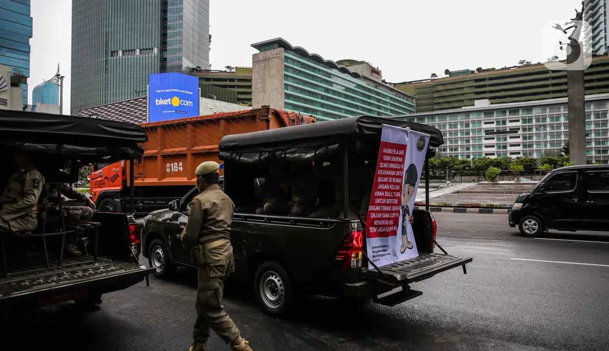 Petugas Satpol PP melakukan sosialisasi kepada masyarakat guna mencegah penularan Covid-19 di Bundaran HI, Jakarta, Kamis (19/3/2020). Sosialisasi yang mengajak masyarakat untuk menerapkan PHBS untuk mengantisipasi penyebaran Covid-19. (Liputan6.com/Faizal Fanani)