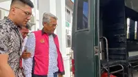 Mantan Bupati Kuansing Sukarmis digiring penyidik ke mobil tahanan setelah menjadi tersangka korupsi hotel Kuansing. (Liputan6.com/M Syukur)