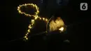 Seorang relawan menyalakan lampu pada malam renungan Hari AIDS Sedunia di Tanah Abang, Jakarta, Rabu (1/12/2021). Acara ini digelar secara gabungan oleh lembaga dan relawan pendamping orang dengan HIV/AIDS (ODHA). (Liputan6.com/Herman Zakharia)