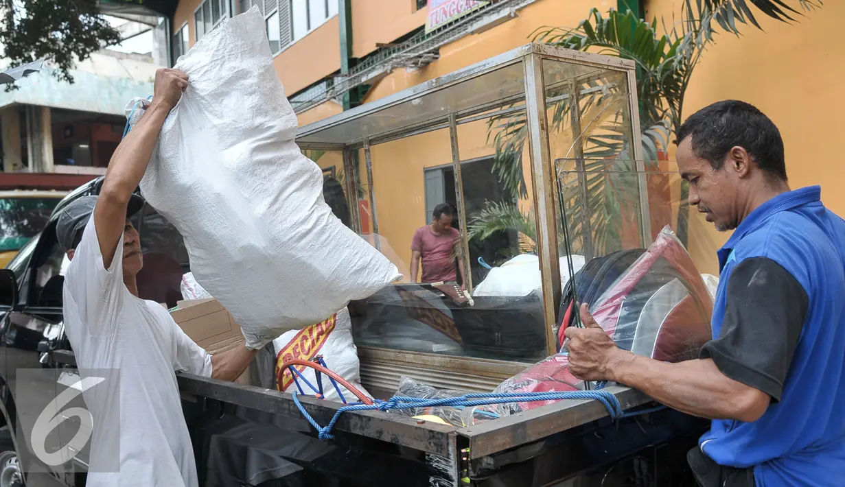 Pedagang mengangkut perlengkapan dagang ke Tempat Penampungan Sementara (TPS), Manggarai, Jakarta, Selasa (4/10). Pedagang Pasar Rumput mulai tempati kios TPS Pasar Jaya Manggarai. (Liputan6.com/Yoppy Renato)