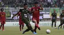 Bek Tira Persikabo, Vava Mario, berebut bola dengan gelandang Kalteng Putra, Fajar Handika, pada laga Shopee Liga 1 di Stadion Pakansari, Bogor, Jumat (26/7). Tira Persikabo menang 5-2 atas Kalteng. (Bola.com/Yoppy Renato)