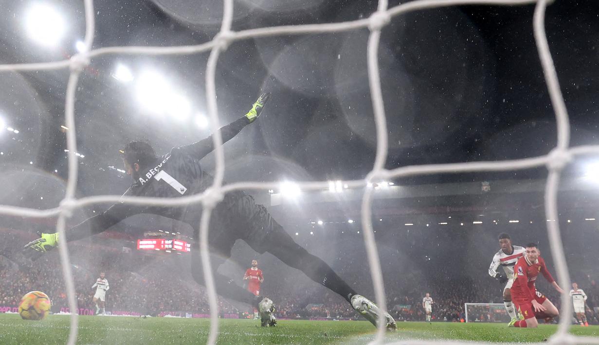 Kiper Alisson Becker gagal menghalau bola tendangan pemain Manchester United, Amad Diallo pada laga lanjutan Liga Inggris 2024/2025 di Anfiled, Liverpool, Inggris, Minggu (05/01/2025). (AFP/Darren Staples)