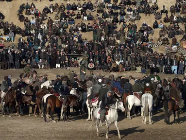 Para penunggang kuda Afghanistan bersaing memperebutkan bangkai saat pertandingan olahraga tradisional Buzkashi di Mazar-i-Sharif, Afghanistan (20/12). Buzkashi adalah olahraga tradisional yang cukup populer di kawasan Asia Tengah. (AFP/Farshad Usyan)