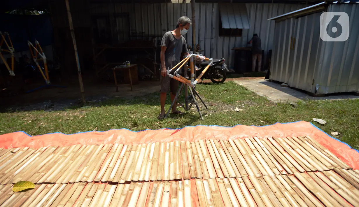 Pekerja menyelesaikan pembuatan sepeda yang terbuat dari bambu di Workshop Arana Bike, Gunung Putri, Kabupaten Bogor, Jawa Barat, Selasa (15/3/2022). Tipe Komodo dan Minivelo dijual dengan harga Rp 5 juta per rangkanya. (merdeka.com/Imam Buhori)