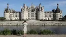 Seorang pengunjung mengambil gambar Kastil Chambord, di Chambord, Prancis pada 22 Juli 2020. Bangunan bersejarah ini merupakan salah satu kastil terbesar di Prancis sekaligus lokasi nyata yang menginspirasi film pertama Beauty and The Beast, 26 tahun lalu. (Photo by Ludovic MARIN / AFP)