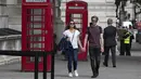 Orang-orang berjalan melewati bilik telepon umum di pusat Kota London, Inggris (8/9/2020). Angka resmi terbaru Inggris pada Selasa (8/9) menunjukkan bahwa korban meninggal akibat COVID-19 di negara tersebut telah mencapai 57.400. (Xinhua/Han Yan)