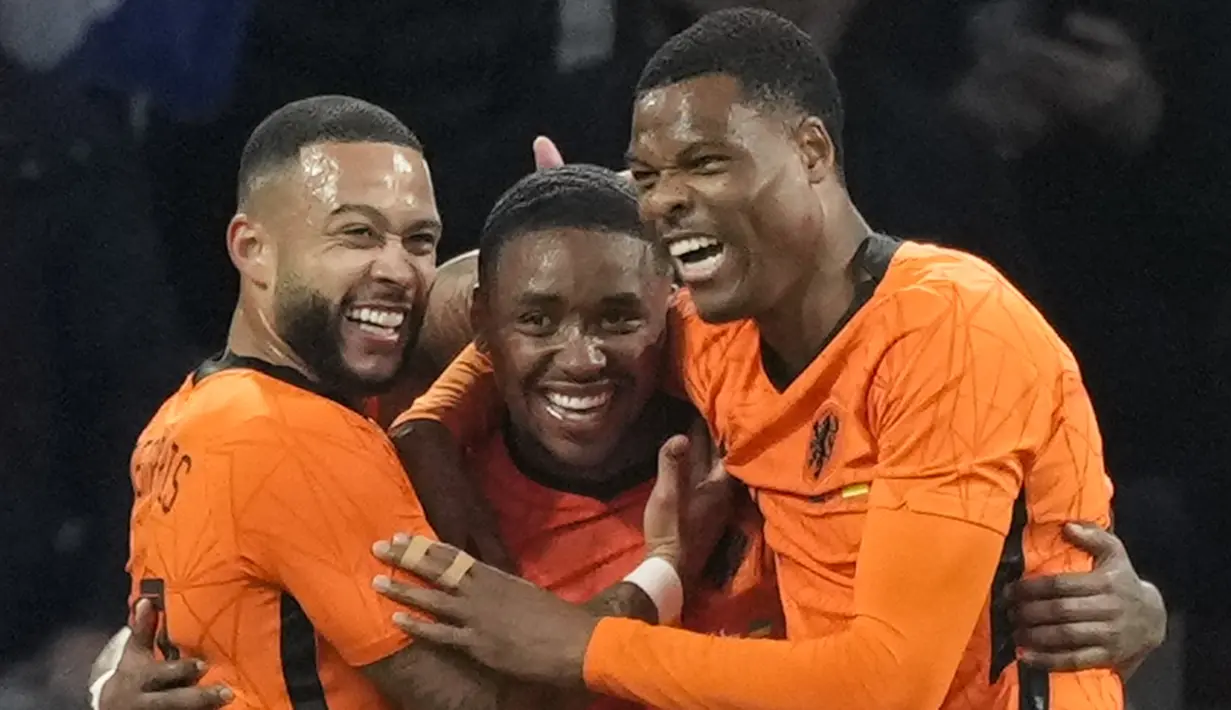 Pemain Belanda Memphis Depay (kiri) dan Denzel Dumfries (kanan) memeluk Steven Bergwijn (tengah) yang mencetak gol ke gawang Denmark pada pertandingan persahabatan di Johan Cruyff ArenA, Amsterdam, Belanda, 26 Maret 2022. Belanda menang 4-2. (AP Photo/Peter Dejong)
