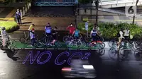 Pegiat bersepeda dan aktivis pecinta lingkungan saat aksi gowes Kelap Kelip Jakarta Night Ride #NOP26 di Kawasan Dukuh Atas, Jalan Jenderal Sudirman, Jakarta, Jumat (26/11/2021). Aksi bertujuan untuk mendorong penggunaan sepeda sebagai solusi transportasi nol emisi. (Liputan6.com/Helmi Fithriansyah)