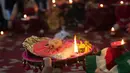 Seorang wanita Hindu yang sudah menikah melakukan ritual festival Karva Chauth di Ahmadabad,  Kamis (17/10/2019). Selama festival Karva Chauth, wanita-wanita yang sudah menikah di India berpuasa sepanjang hari dan memohon umur panjang serta keselamatan untuk suami mereka. (AP/Ajit Solanki)