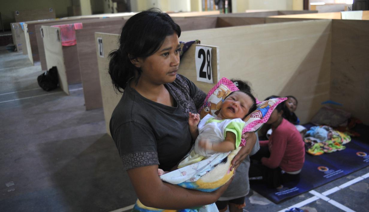 Seorang wanita tampak menggendong bayinya di penampungan sementara di Magelang, Jawa Tengah, 7 November 2020. Pihak berwenang mengevakuasi ratusan orang yang tinggal di lereng Gunung Merapi menyusul peningkatan aktivitas vulkanis. (Xinhua/Supriyanto)