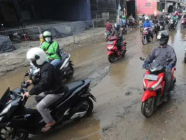 Pengendara motor menghindari lubang yang cukup dalam akibat jalan yang rusak di Jalan Raya Bojonggede, Bogor Senin (11/5/2020). Beberapa titik jalan yang menghubungkan Citayam Depok - Bojonggede Bogor mengalami kerusakan yang cukup parah sejak tiga bulan terakhir. (merdeka.com/Arie Basuki)