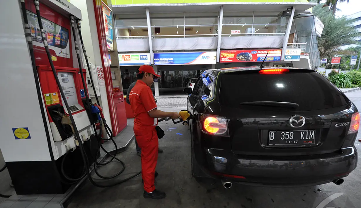 Petugas SPBU sedang mengisi bahan bakar ke salah satu kendaraan roda empat Seiring dengan terus melorotnya harga minyak dunia, Jakarta, Kamis (1/1/2015). (Liputan6.com/Miftahul Hayat)