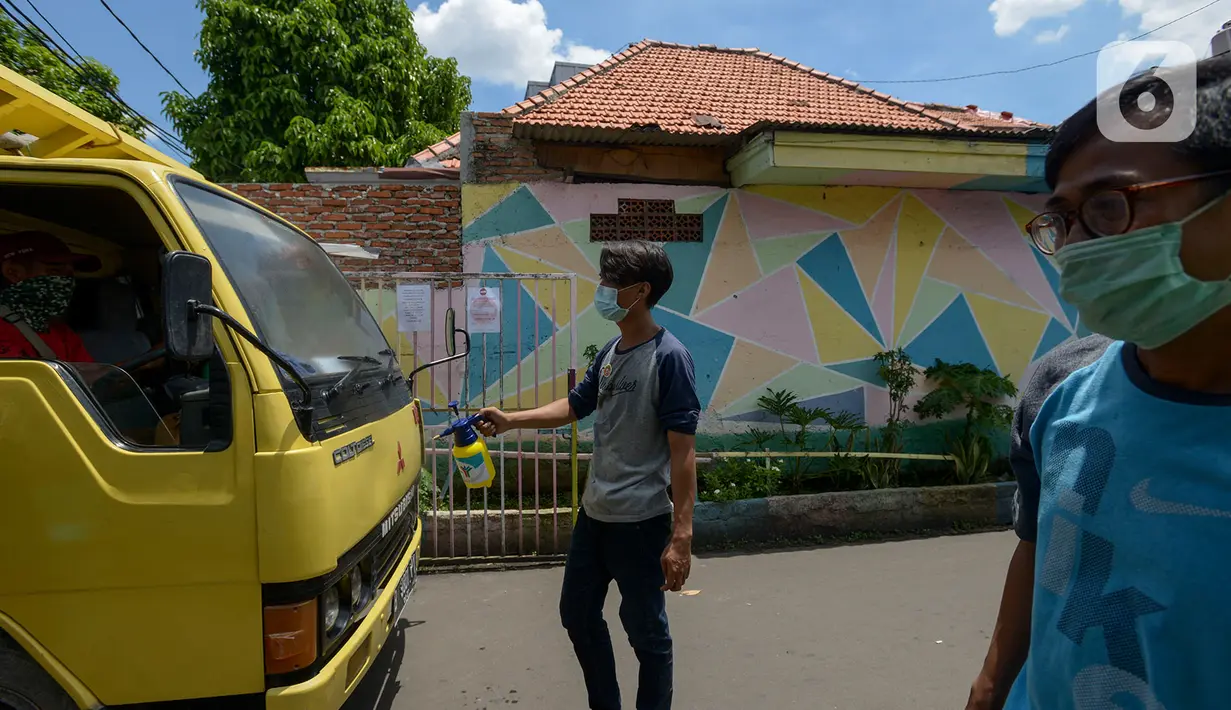 Anggota Karang Taruna menyemprotkan cairan disinfektan ke kendaraan yang memasuki pemukiman di Kelurahan Kebon Sirih, Jakarta, Rabu (1/4/2020). Warga di kelurahan itu memberlakukan akses satu pintu masuk dan menyemprotkan disinfektan guna mencegah penyebaran virus COVID-19. (merdeka.com/Imam Buhori)