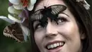 Jessie May Smart tersenyum saat berpose dengan yang menghinggapi wajahnya, sebelum pembukaan, "Butterflies in the Glasshouse", di RHS Wisley di Wisley, Inggris, (13/1). Ditempat ini sedikitnya terdapat 6.000 kupu-kupu yang hidup bebas. (AFP/Adrian Dennis)