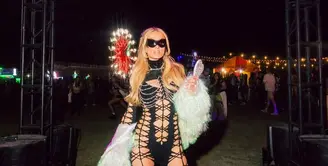 Paris Hilton tampil maksimal mengenakan pakaian berjaring warna hitam selaras dengan sepatu boots dan kacamata hitamnya. Ia memadukannya dengan jaket fur putih. [@parishilton]
