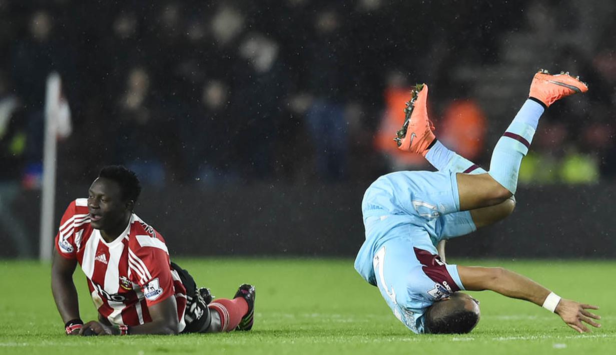 Pemain Southampton, Victor Wenyama dan pemain West Ham, Dimitri Payet, terjatuh saat berlaga di Stadion St Mary, Inggris, Sabtu (6/2/2016). Southampton berhasil menang 1-0 atas West Ham. (Reuters/Hannah McKay)