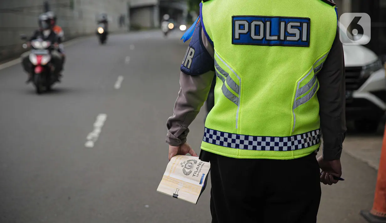 Polisi membawa surat tilang saat melakukan Operasi Zebra Jaya 2021 di kawasan Jalan Gatot Subroto, Jakarta, Selasa (16/11/2021). Operasi Zebra Jaya 2021 digelar untuk meningkatkan kedisiplinan masyarakat dalam berlalu lintas. (Liputan6.com/Faizal Fanani)