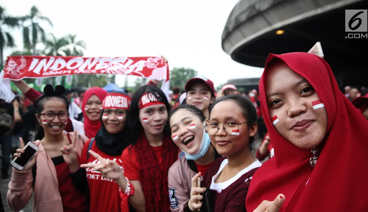 Sejumlah suporter wanita melukis pipinya dengan gambar bendera Merah Putih jelang semifinal SEA Games 2017 di Stadion Sham Alam Selangor, Malaysia, Sabtu (26/8). Timnas Indonesia U-22 bakal berlaga melawan Malaysia. (Liputan6.com/Faizal Fanani)