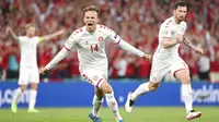 Pemain muda Denmark, Mikkel Damsgaard, merayakan gol yang dicetaknya ke gawang Rusia. Ia sukses mengukir rekor sebagai pencetak gol termuda untuk Denmark di Euro dengan usai 20 tahun 353 hari. (Jonathan Nackstrand/Pool via AP)