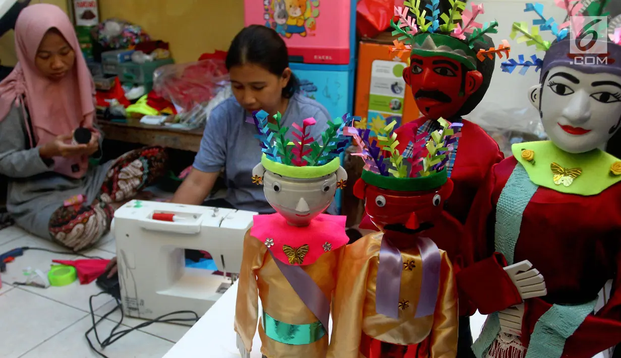 Perajin menyelesaikan pembuatan miniatur ondel-ondel di rumah produksi Kramat Jati, Jakarta, Senin (23/6/2019). Perajin dapat memproduksi 50  hingga 80 miniatur ondel-ondel dalam sebulan. (merdeka.com/Arie Basuki)