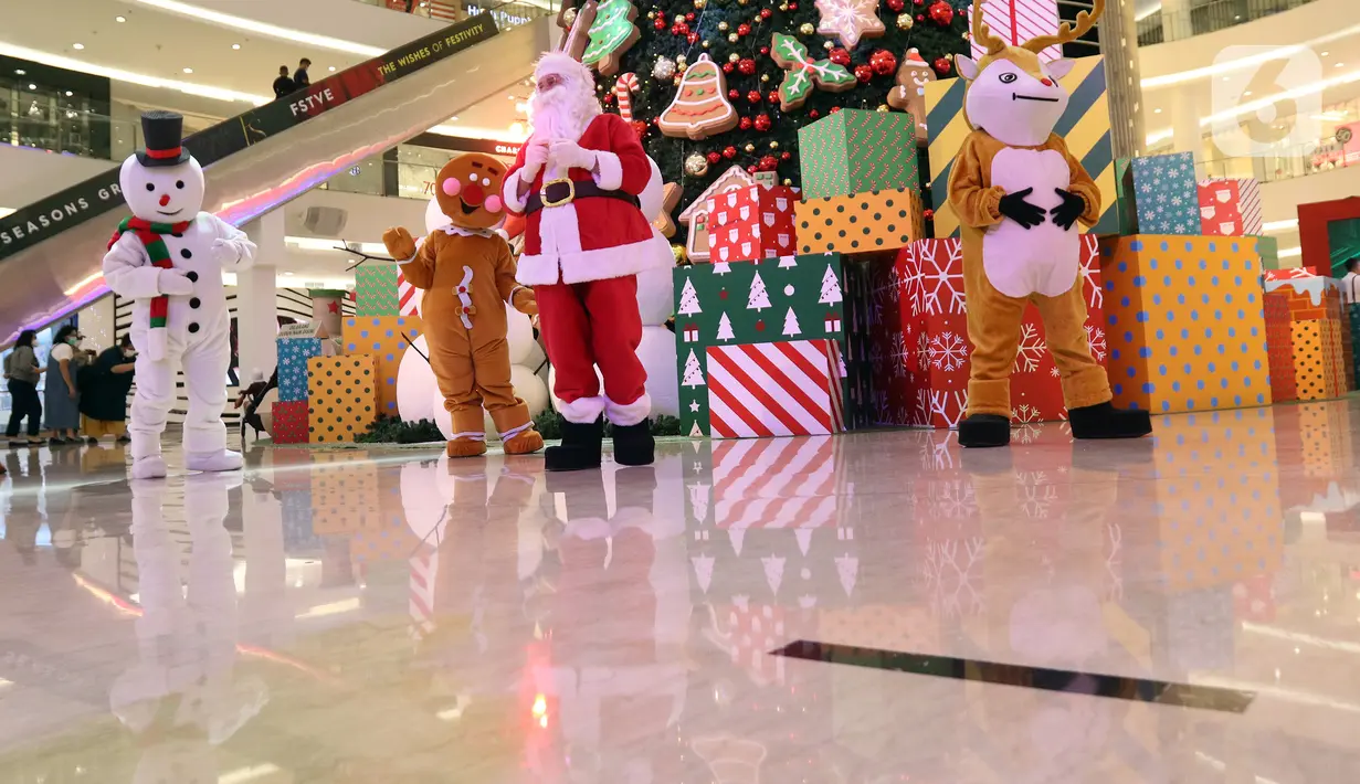 Petugas mengenakan kostum Sinterklas saat menghibur pengunjung di Senayan City Mall, Jakarta, Jumat (25/12/2020). Kegiatan tersebut bertujuan untuk melengkapi kebahagiaan Natal tahun 2020. (Liputan6.com/Herman Zakharia)