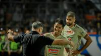 Pelatih Persija Jakarta, Thomas Doll memberikan selamat kepad Hanif Sjahbandi dan Abdulla Yusuf setelah timnya menang 1-0 atas Arema FC di Stadion Kanjuruhan, Malang, Minggu (29/8/2022). (Bola.com/Iwan Setiawan)