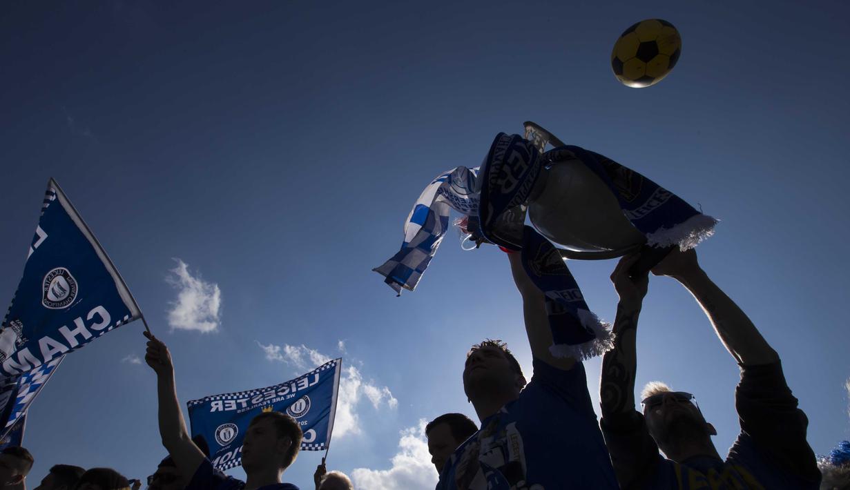 Fans Leicester mengibarkan bendera menyambut trofi juara Liga Inggris 2015/2016 di dekat Victoria Park, Leicester, (16/5/2016). (EPA/Jon Super)