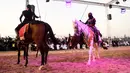 Perempuan Arab mengibarkan kain putih saat menunggangi kuda dalam Festival Souk Okaz 2019 di Kota Taif, Arab Saudi, Rabu (7/8/2019). Perempuan penunggang kuda dari berbagai negara Arab ambil bagian dalam Festival Souq Okaz 2019. (AMER HILABI/AFP)