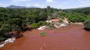 Banjir yang dipicu jebolnya bendungan menerjang rumah warga di Brumadinho, Brasil, Jumat (25/1). Beberapa orang yang terperangkap berhasil dievakuasi, dalam kondisi seluruh tubuh berselimut lumpur. (Bruno Correia/Nitro via AP)