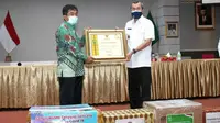 Gubernur Riau Syamsuar menyerahkan penghargaan kepada SEVP Operasional PTPN V Ospin Sembiring karena kepedulian terhadap Covid-19 di Riau. (Liputan6.com/Istimewa)