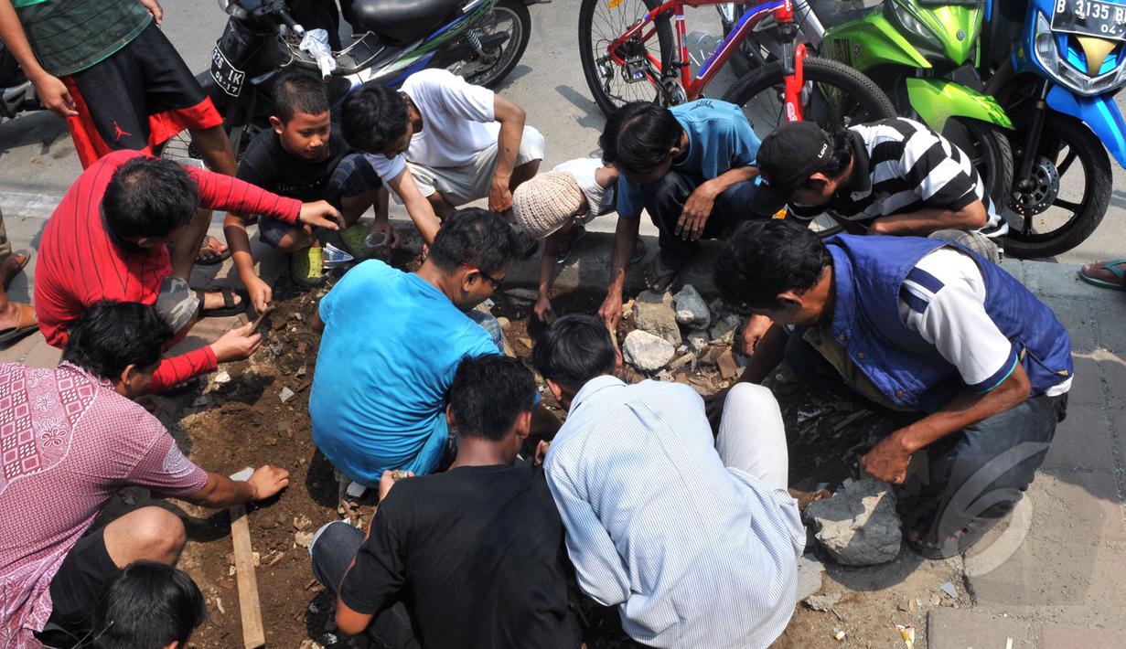 Sejumlah warga memadati lokasi tempat ditemukannya batu yang diduga jenis Giok di Kawasan Tomang, Jakarta, Sabtu, (9/5/2015). (Liputan6.com/Andrian M Tunay)