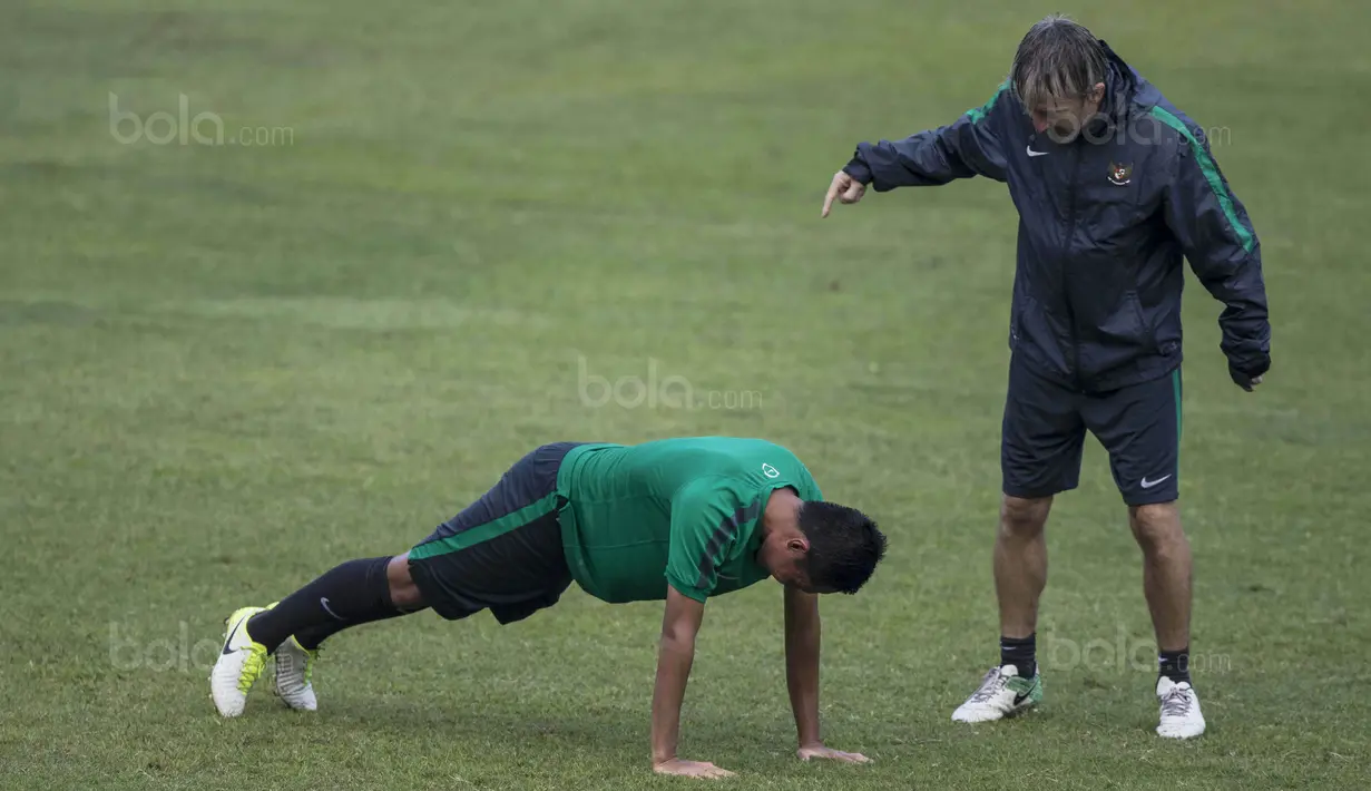 Gelandang Timnas Indonesia, Evan Dimas, diminta pelatih fisik, Miguel Gandia, untuk push up usai latihan di Stadion UKM, Selangor, Sabtu (19/8/2017). Evan kalah saat bermain crossbar dengan Miguel. (Bola.com/Vitalis Yogi Trisna)