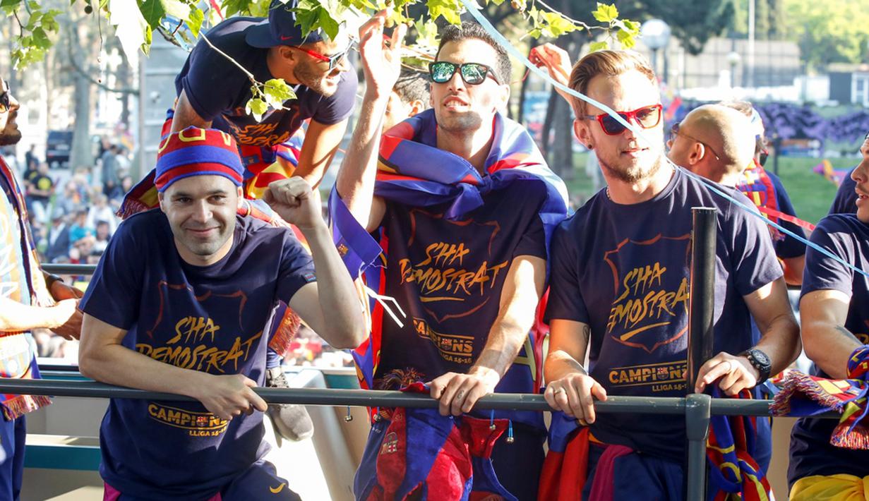 Andres Iniesta, Sergio Busquets, dan Ivan Rakitic saat berpawai dengan menggunakan bus untuk merayakan gelar La Liga ke-24, Minggu (15/5/2016). (AFP/Pau Barrena)