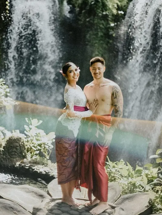 Liburan di Bali, Millen Cyrus tampil anggun berbalut kebaya Bali berwarna putih dan selendang fuschia yang diikat di pinggangnya. @millencyrus